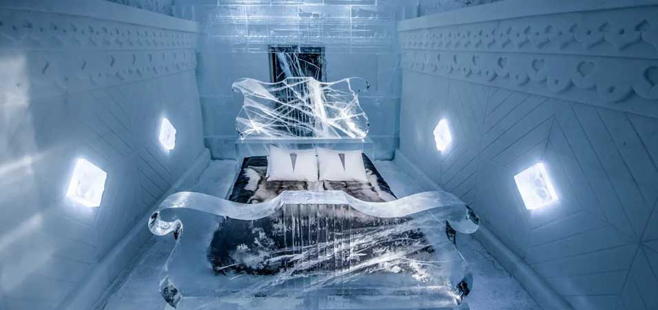 The Ice Hotel in Sweden glowing with blue light at night
